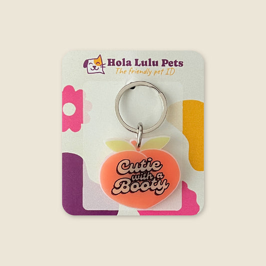 Funny "Cutie With A Booty" peach illustration on a durable white acrylic QR code dog tag by Hola Lulu Pets.